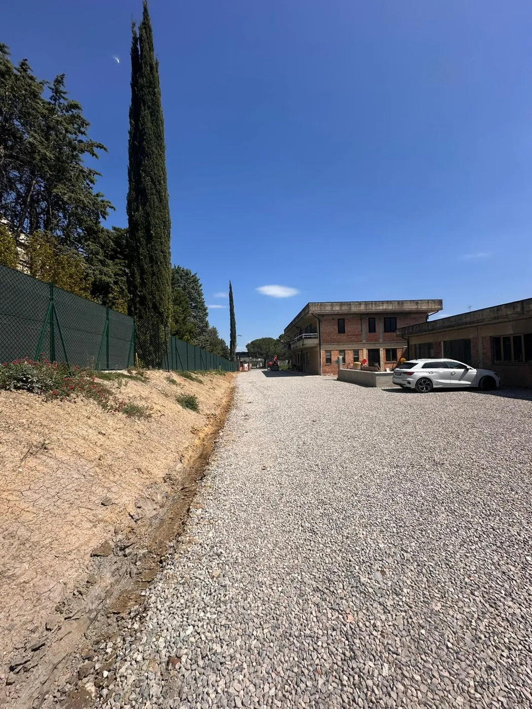 Realizzazione e sistemazione di piazzale in ghiaia, con preparazione del fondo, livellamento, stesa del materiale e compattazione finale.  L’intervento ha permesso di ottenere una superficie regolare, stabile e drenante, adatta alla viabilità interna, al transito dei mezzi e alle aree di servizio. La lavorazione è stata eseguita curando anche le pendenze e la regimazione laterale delle acque, così da migliorare funzionalità e durata del piazzale.